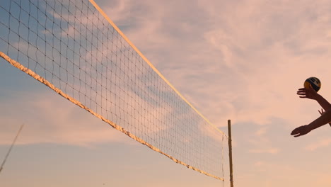 Sexy-Volleyballspielerinnen-Passen-Den-Ball-In-Der-Nähe-Des-Netzes-Hin-Und-Her-Und-Schlagen-Den-Ball-Bei-Sonnenuntergang-In-Zeitlupe.